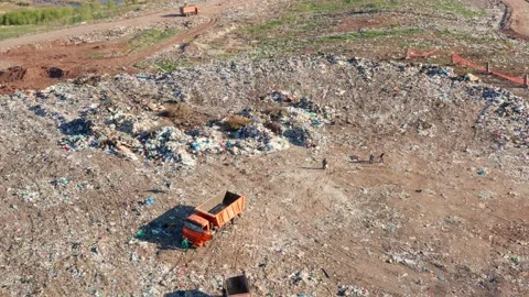 A group of workers at the city dump in the afternoon, a blue lake in the Stock Footage 153740164