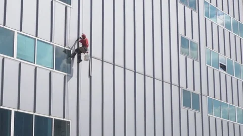 Group of workers cleaning windows service on high rise building Stock Footage 76203318