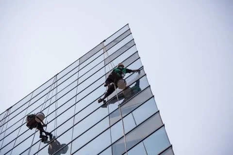 Group of workers cleaning windows service on high rise building Stock Photos