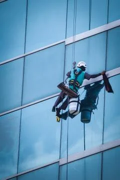 Group of workers cleaning windows service on high rise building Stock Photos