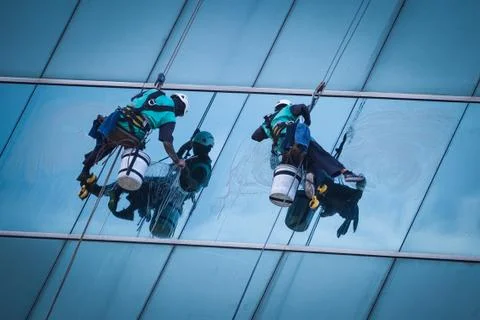 Group of workers cleaning windows service on high rise building Stock Photos