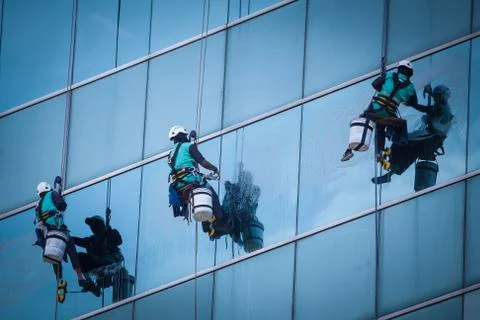 Group of workers cleaning windows service on high rise building Stock Photos