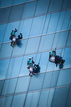 Group of workers cleaning windows service on high rise building Foto stock