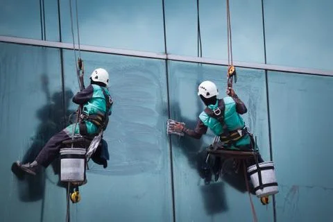 Group of workers cleaning windows service on high rise building Stock Photos