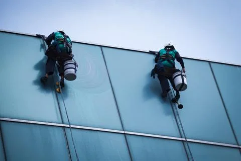 Group of workers cleaning windows service on high rise building Stock Photos