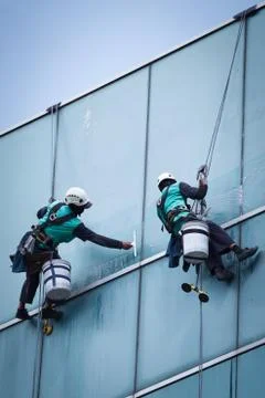 Group of workers cleaning windows service on high rise building Foto stock