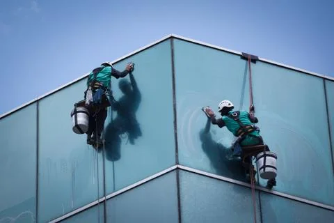 Group of workers cleaning windows service on high rise building Stock Photos