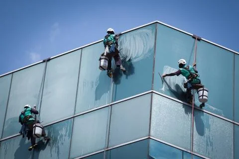 Group of workers cleaning windows service on high rise building Stock Photos