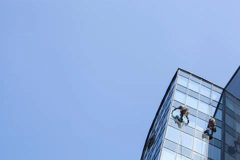 Group of workers cleaning windows service on high rise building Stock Photos