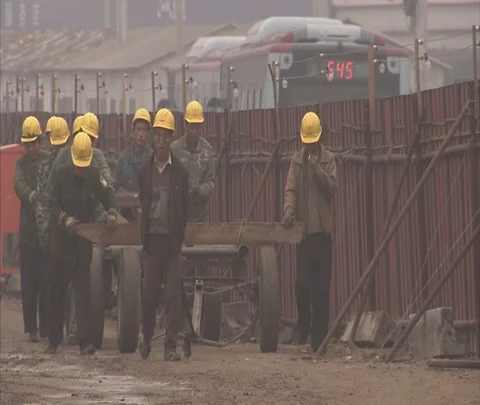 Group of workers in hard hats pull cart on construction site Stock Footage 86744242
