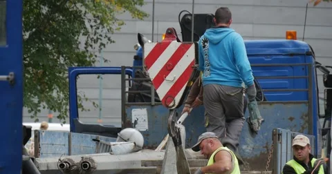 Group of Workers Men in Workwear Are Fixing The Tube to The Crane Hook Stock Footage 54337296