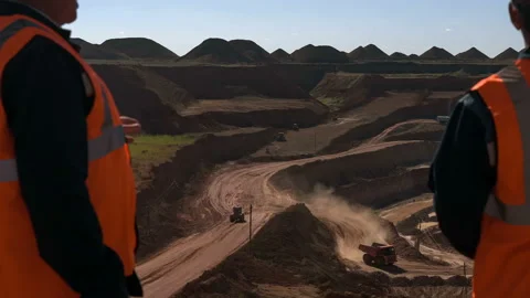 Group of workers in overalls actively speaking on board a bauxite quarry. Stock Footage 88796073