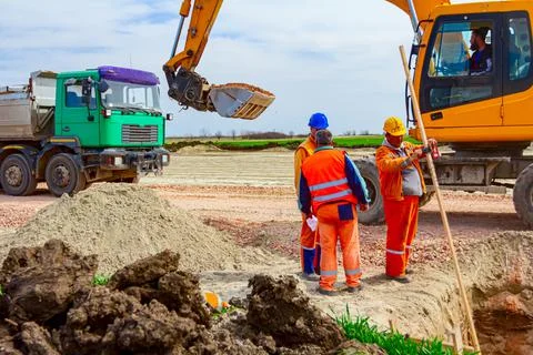 Group of workers with safety vests and helmets at construction site Stock Photos