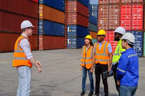 Group of workers teamwork at logistics dock with many stacks of containers. Foto stock