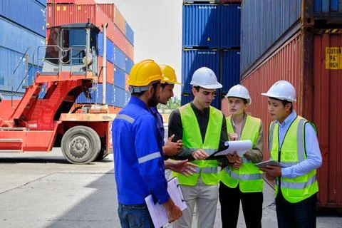 Group of workers teamwork at logistics terminal with many stacks of container Foto stock