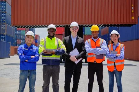 Group of workers teamwork at logistics terminal with many stacks of container Stock Photos