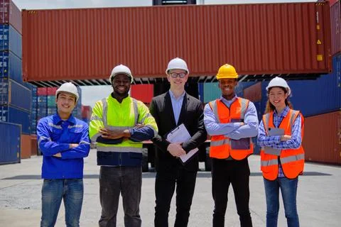 Group of workers teamwork at logistics terminal with many stacks of container Stock Photos