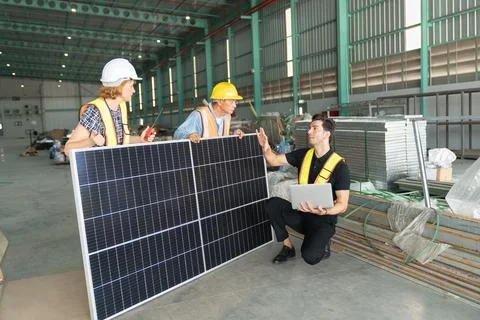 Group of workers using solar panels in warehouse. Foto stock