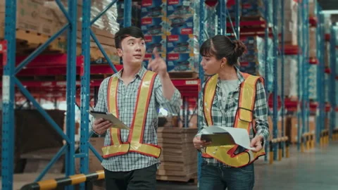 Group of  workers wearing helmet checking inventory and discussing in modern  Stock Footage 204917492