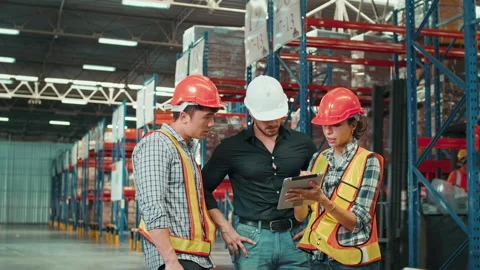Group of  workers wearing helmet checking inventory and discussing in modern  Видео 204917802