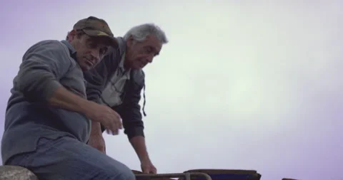 Group of workmen working together on moving construction parts during cloudy day Stock Footage 158643584