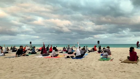 Group Yoga Class on the Sand Beach at Sunset Stock Footage 102538887