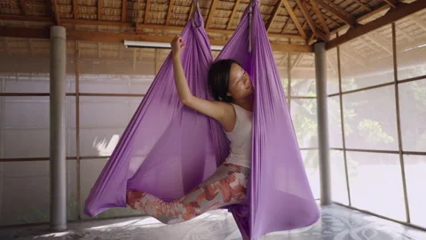 Group of yogi students get into corpse position inside of hanging hammocks at Stock Footage 218353550