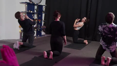 Group of yogis move smoothly during yoga session at sport studio Stock Footage 156822638