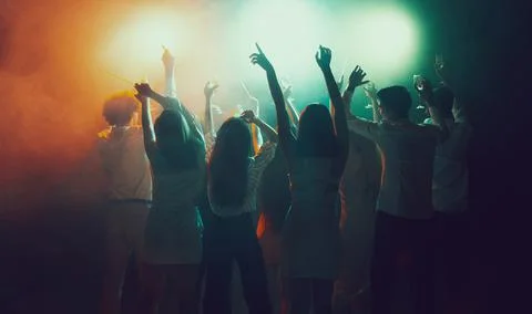 Group of young, active people at the night club, party dancing in neon lights Stock Photos