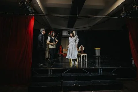 Group of young actors performing a dramatic scene on a stage in a theater Stock Photos