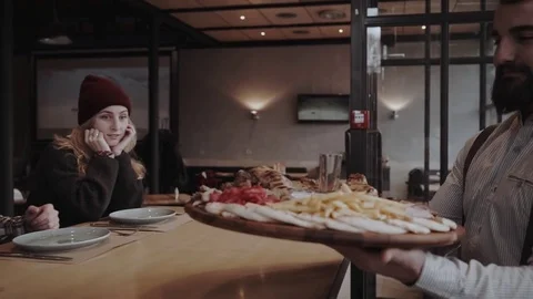 Group of young adults are getting their order of a meat plate at the cafe Stock Footage 85366869