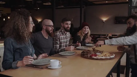 Group of young adults are getting a meat food plate Stock Footage 85366884