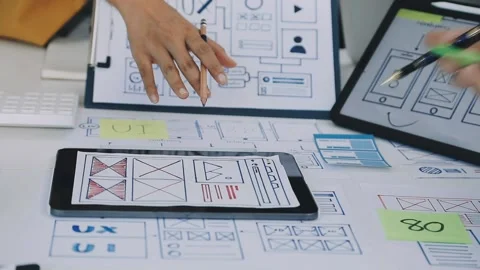 Group of young application developers analyzing uxui mobile app templates d.. Stock Footage 316828038