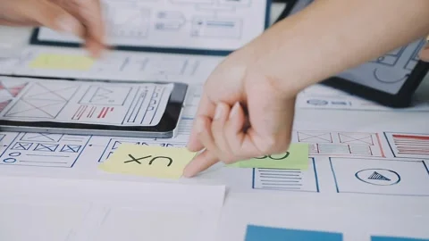 Group of young application developers analyzing uxui mobile app templates d.. Stock Footage 316828041