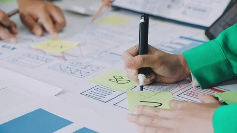 Group of young application developers analyzing uxui mobile app templates d.. Stock Footage 316828052