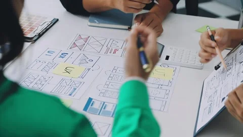 Group of young application developers analyzing uxui mobile app templates d.. Stock Footage 316828055