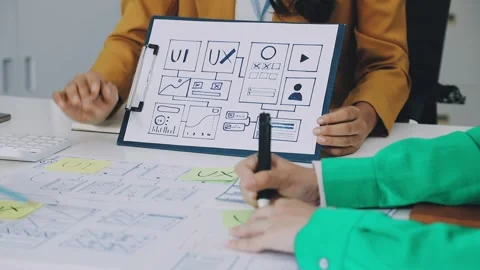 Group of young application developers analyzing uxui mobile app templates d.. Stock Footage 316828057