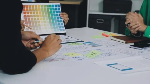 Group of young application developers analyzing uxui mobile app templates d.. Stock Footage 316828084