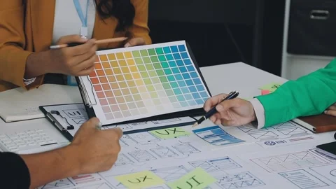 Group of young application developers analyzing uxui mobile app templates d.. Stock Footage 316828091