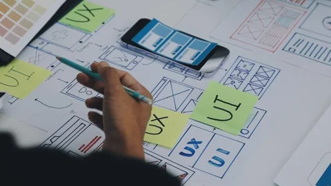 Group of young application developers analyzing uxui mobile app templates d.. Stock Footage 316828098