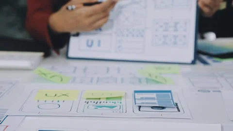 Group of young application developers analyzing uxui mobile app templates d.. Stock Footage 316828099