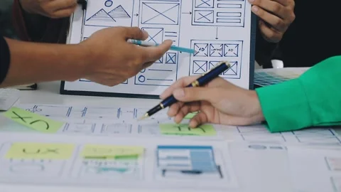 Group of young application developers analyzing uxui mobile app templates d.. Stock Footage 316828112