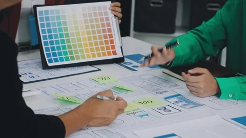 Group of young application developers analyzing uxui mobile app templates d.. Stock Footage 316828120
