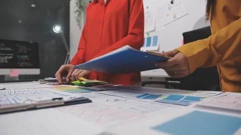 Group of young application developers analyzing uxui mobile app templates d.. Stock Footage 320526443