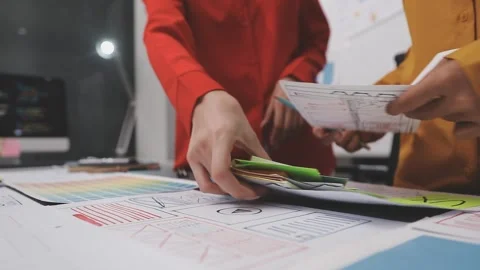 Group of young application developers analyzing uxui mobile app templates d.. Stock Footage 320526445