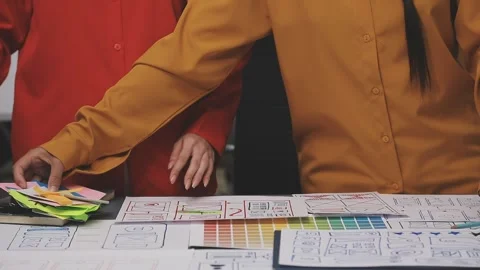 Group of young application developers analyzing uxui mobile app templates d.. Stock Footage 320526462