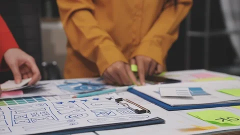 Group of young application developers analyzing uxui mobile app templates d.. Stock Footage 320526476