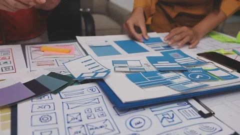Group of young application developers analyzing uxui mobile app templates d.. Stock Footage 320526494