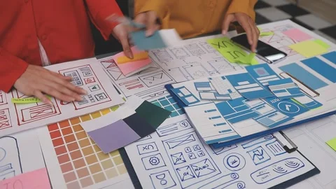 Group of young application developers analyzing uxui mobile app templates d.. Stock Footage 320526495