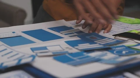 Group of young application developers analyzing uxui mobile app templates d.. Stock Footage 320526500